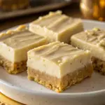 Close-up of creamy No-Bake Cookie Bars with a graham cracker crust and smooth filling, served on a white plate.