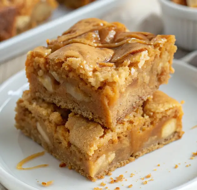 Chewy Butterscotch Blondies stacked on a white plate with a golden caramel drizzle and a soft, buttery texture.