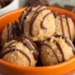 Close-up of Scotcheroo Truffles coated in chocolate and butterscotch, arranged on a parchment-lined tray.