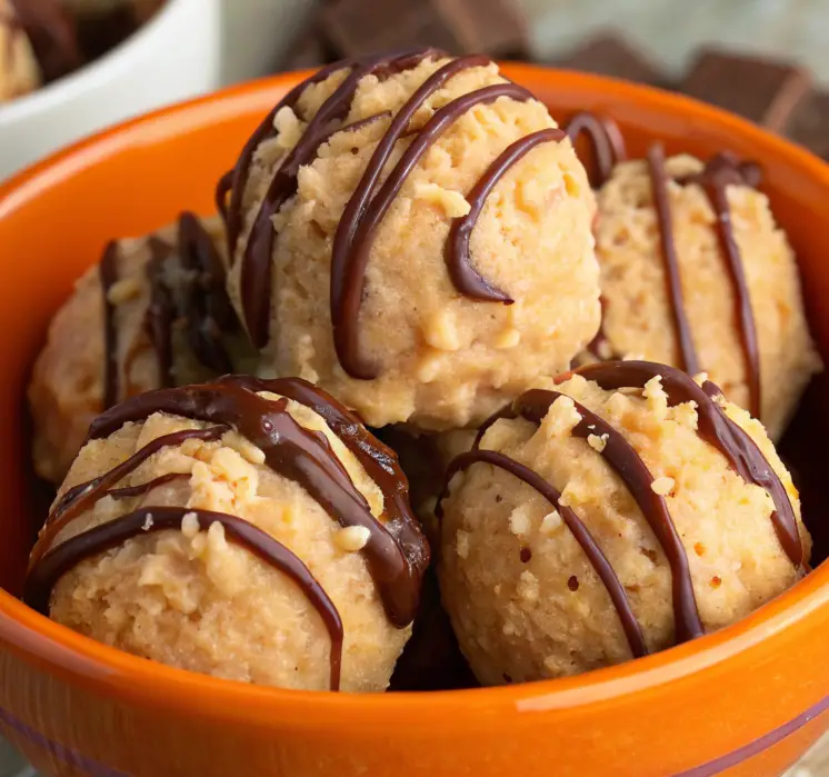 Close-up of Scotcheroo Truffles coated in chocolate and butterscotch, arranged on a parchment-lined tray.