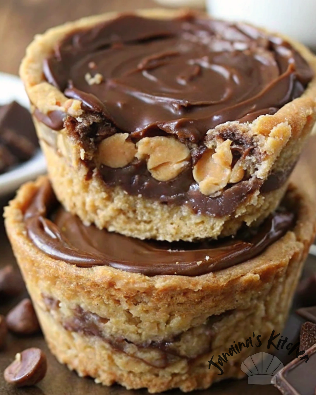 Close-up of two stacked Keto Mini Chocolate Peanut Butter Pies with a golden almond flour crust, creamy peanut butter filling, and a rich chocolate topping. A bite is taken from the top pie, revealing the delicious layers.