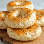 Freshly baked cottage cheese bagels topped with everything seasoning on a wooden board